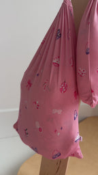 Video of a children's pink sheets hanging on a rack
