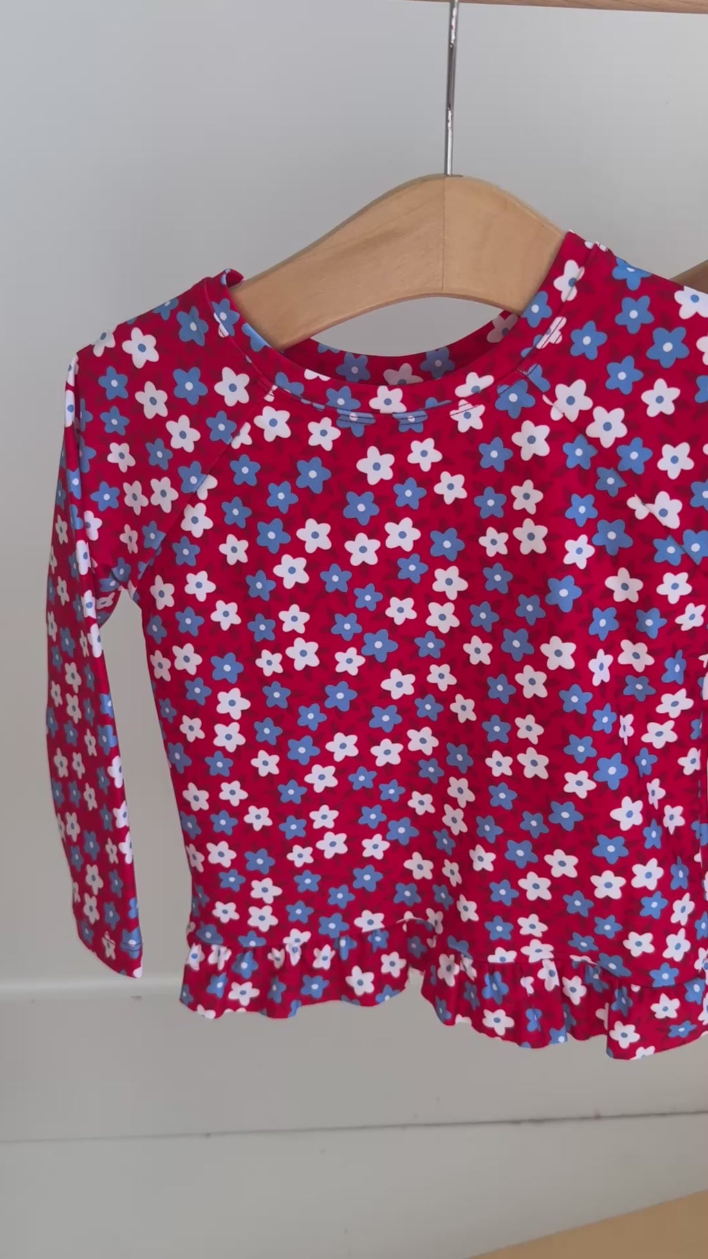 Video of a blue and white floral two-piece swimsuit hanging on a rack