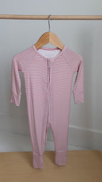 Pink striped onesie hanging on a rack