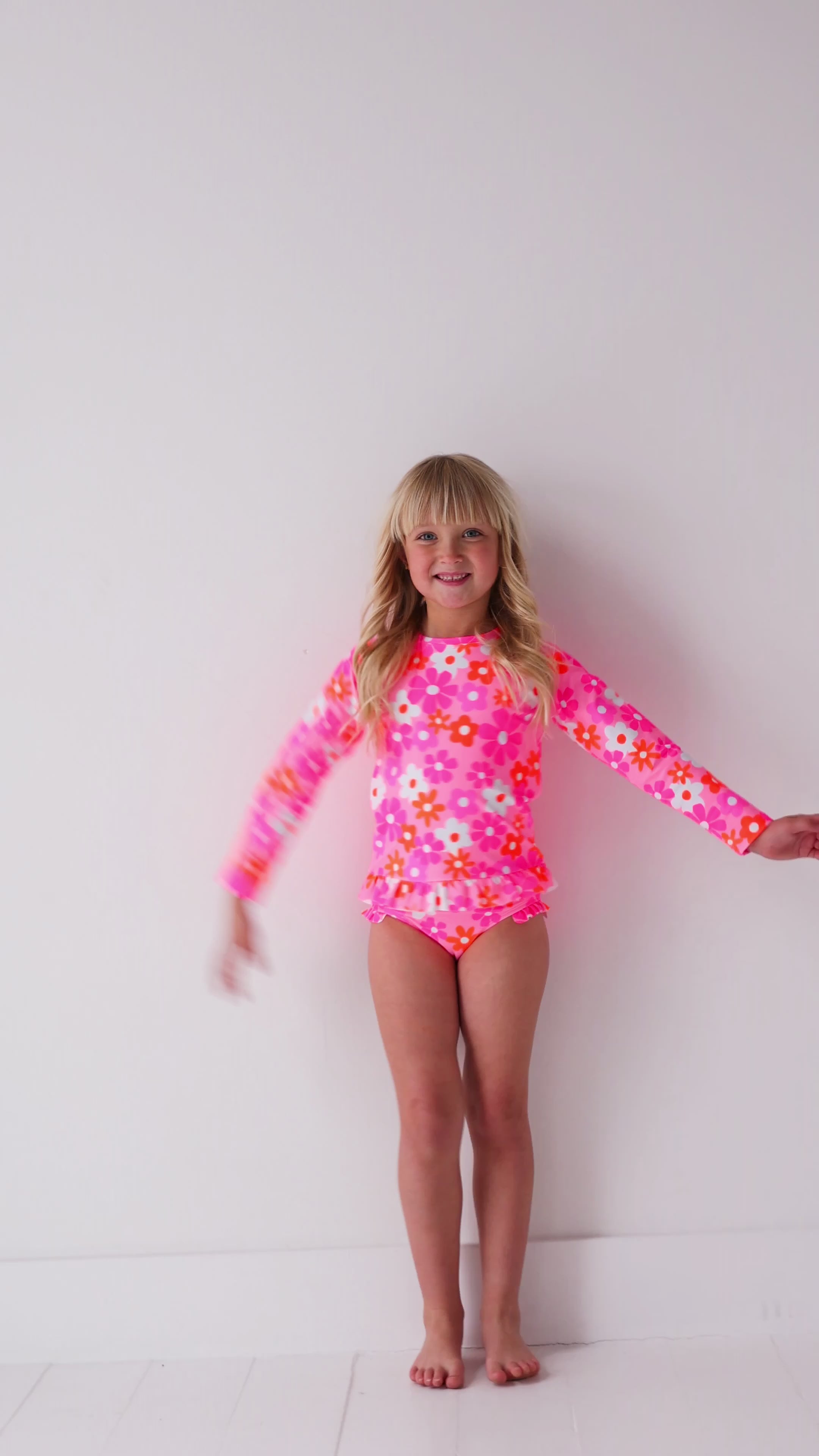 Child wearing a pink floral two-piece swimsuit 