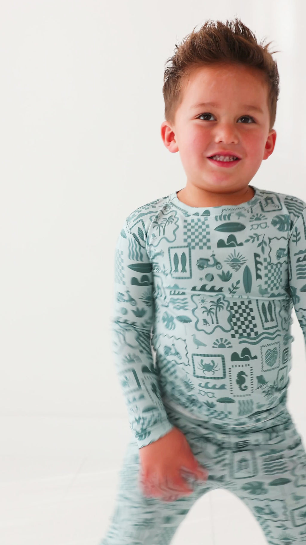 Child wearing a blue summer-patterned pajama set on a white background