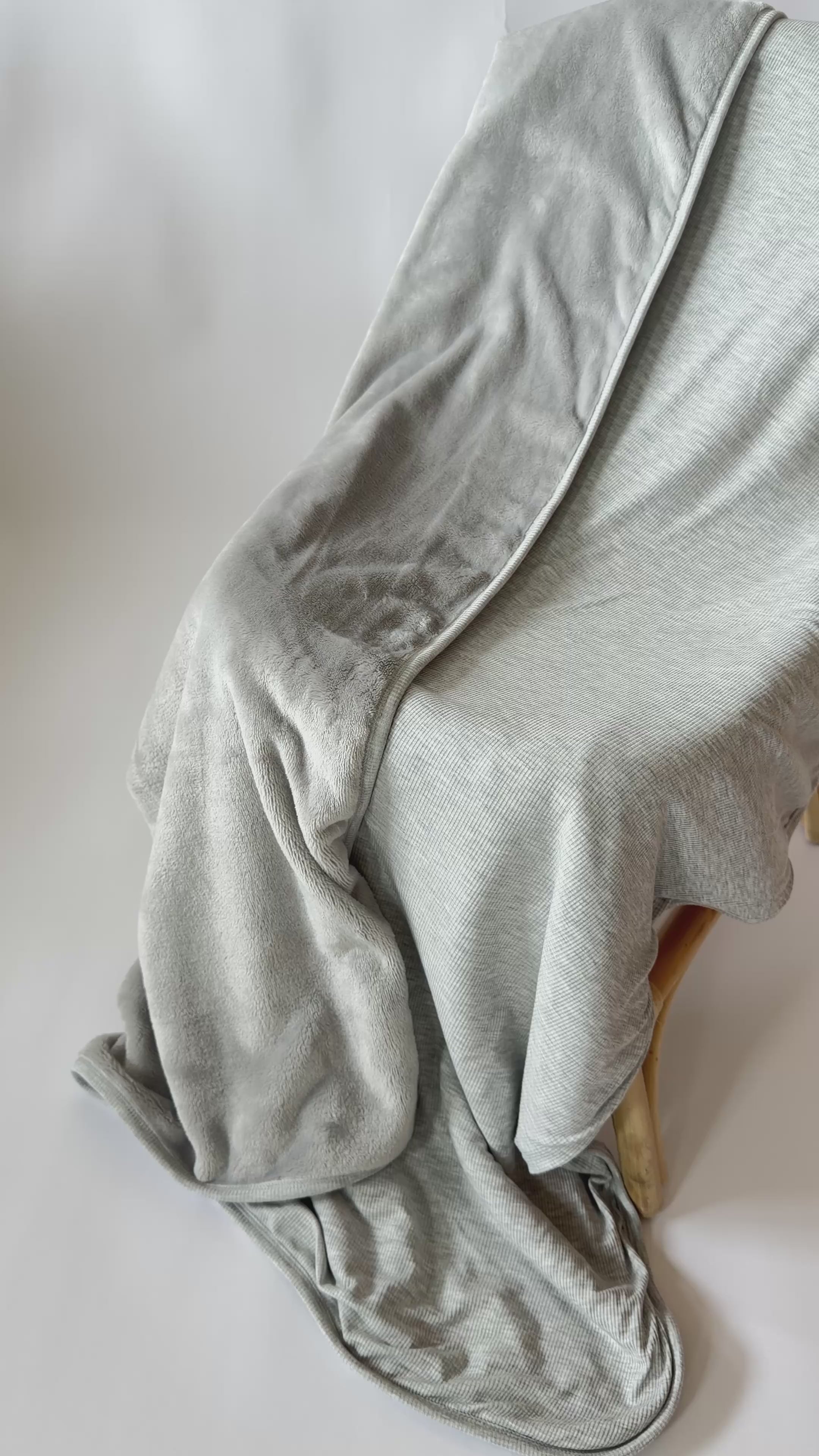 Video of a gray blanket draped over a wooden chair 
