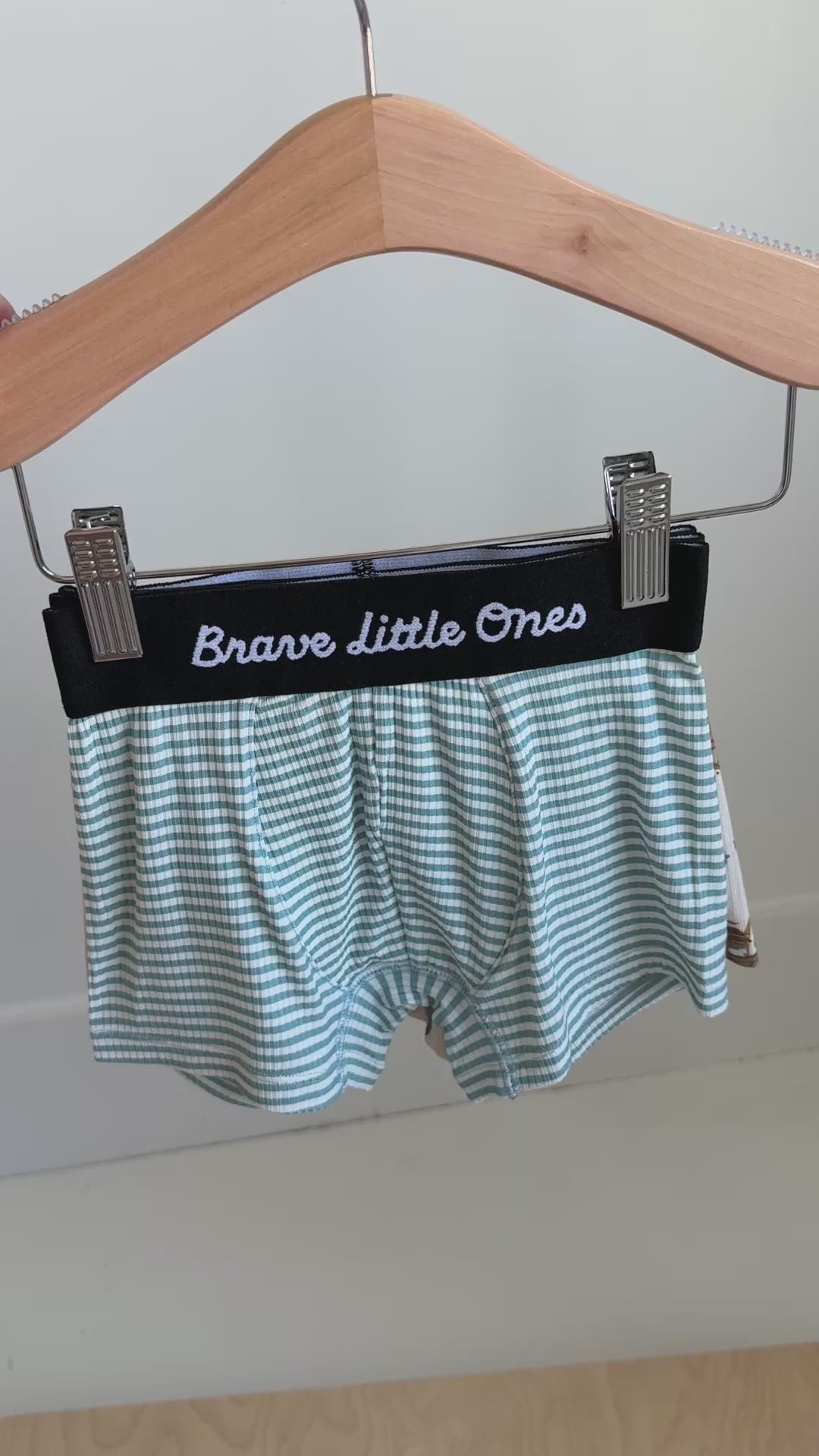Video of a set of children's underwear with 'Brave Little Ones' waistbands hanging on a rack