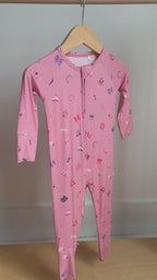 Video of a pink baby onesie with girly patterns hanging on a rack