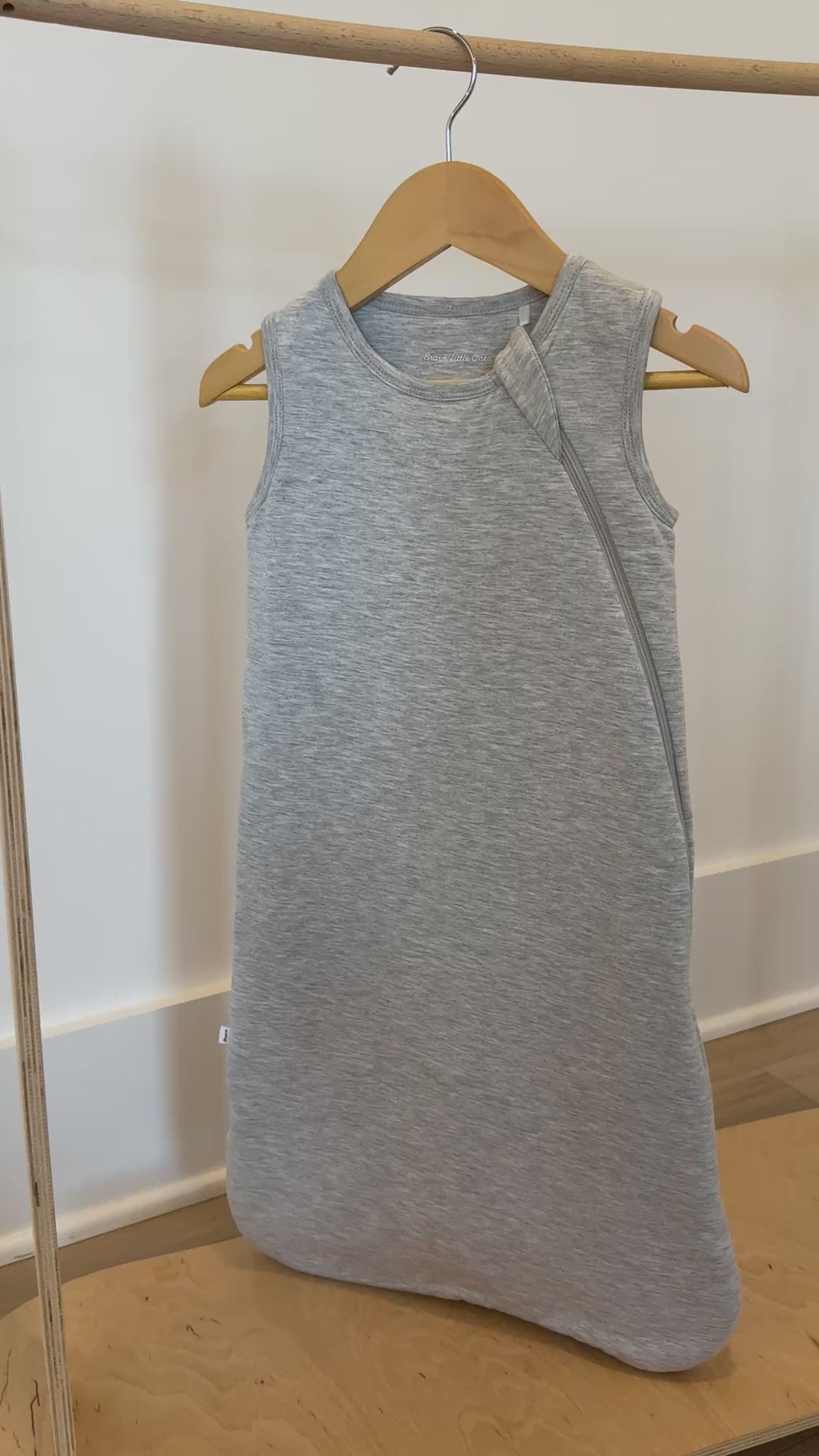 Video of a gray sleeveless sleeping bag hanging on a rack