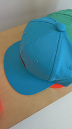 Video of a colorful set of trucker hats on a wooden plank
