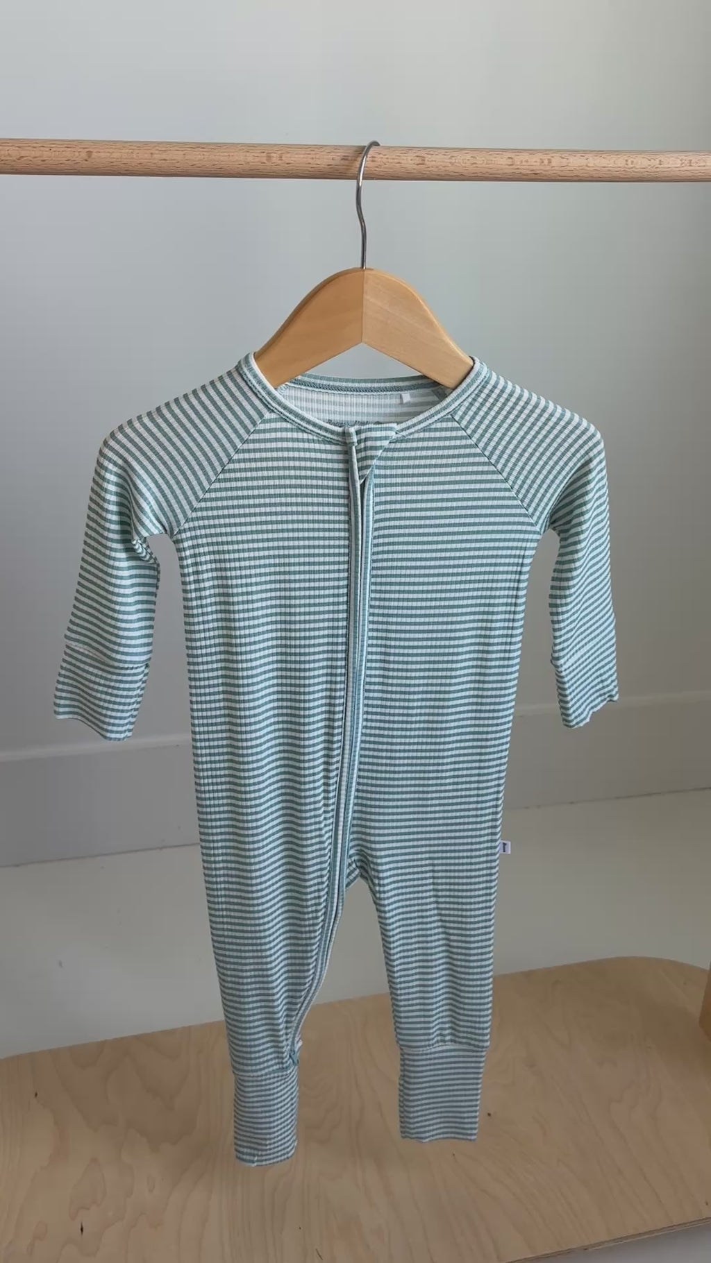 Video of a blue and white striped baby onesie on a white background
