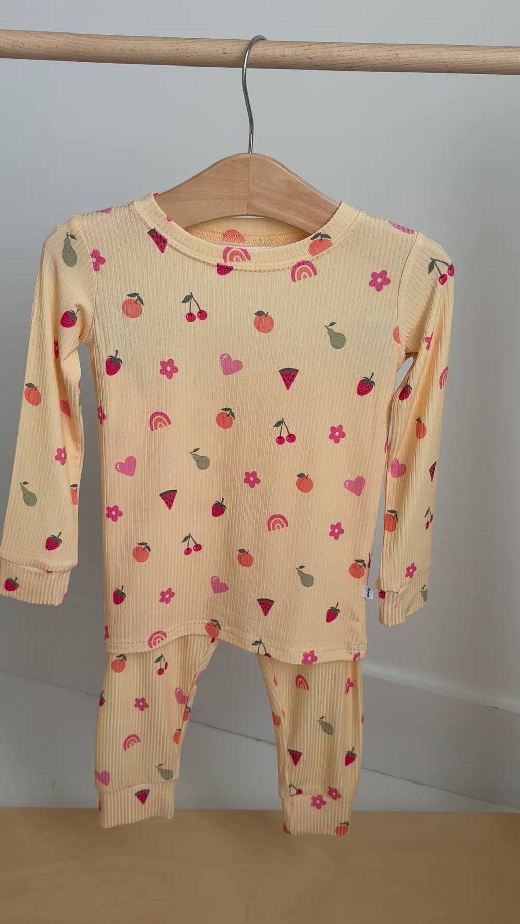 Yellow pajama set with heart patterns hanging on a rack